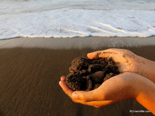 Scooping up black sand Scooping up black sand